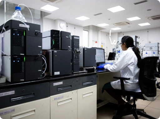 Scientist using an HPLC chromatography system in a modern analytical laboratory for pharmaceutical testing and quality control.