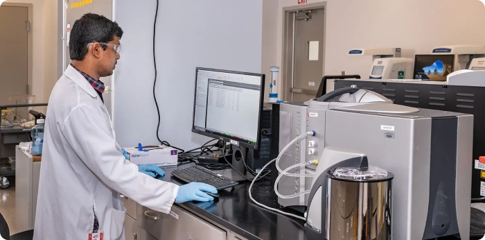 Scientist operating digitally connected analytical instruments in a biologics CDMO laboratory