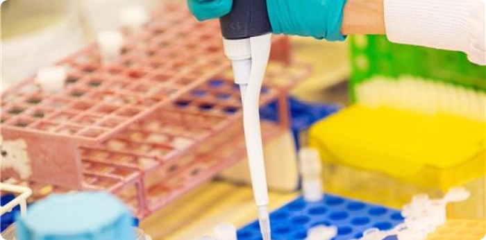 Laboratory technician using a pipette for biologics research and testing