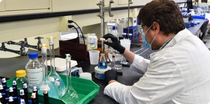 Scientist performing pharmaceutical laboratory analysis and sample testing in a controlled research environment