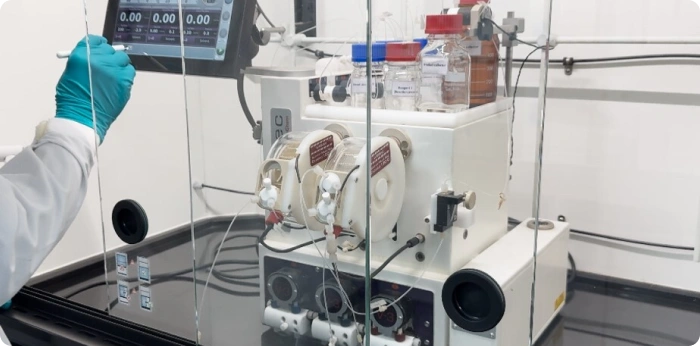 Scientist operating a continuous flow chemistry system used for pharmaceutical process development and scale-up