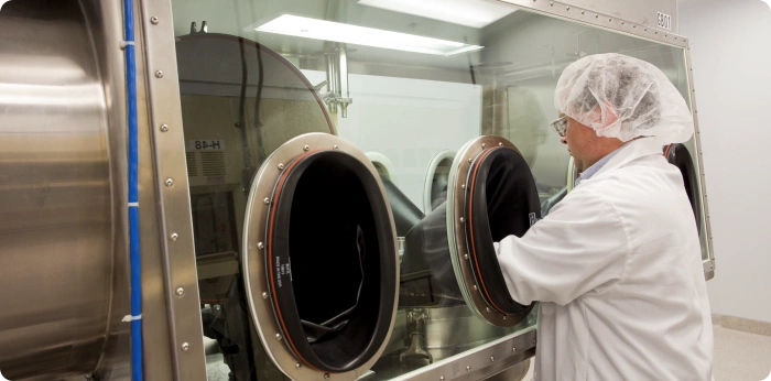 Scientist operating a GMP isolator system for safe handling and manufacturing