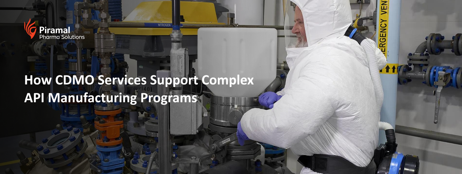 Technician in cleanroom operating pharmaceutical equipment for complex API manufacturing supported by CDMO services