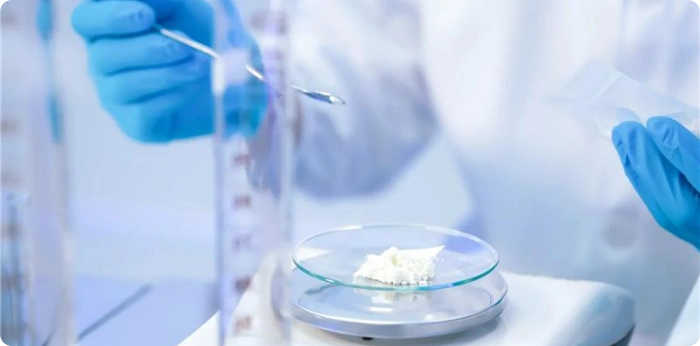 Laboratory scientist weighing pharmaceutical starting material powder for quality testing and analytical research