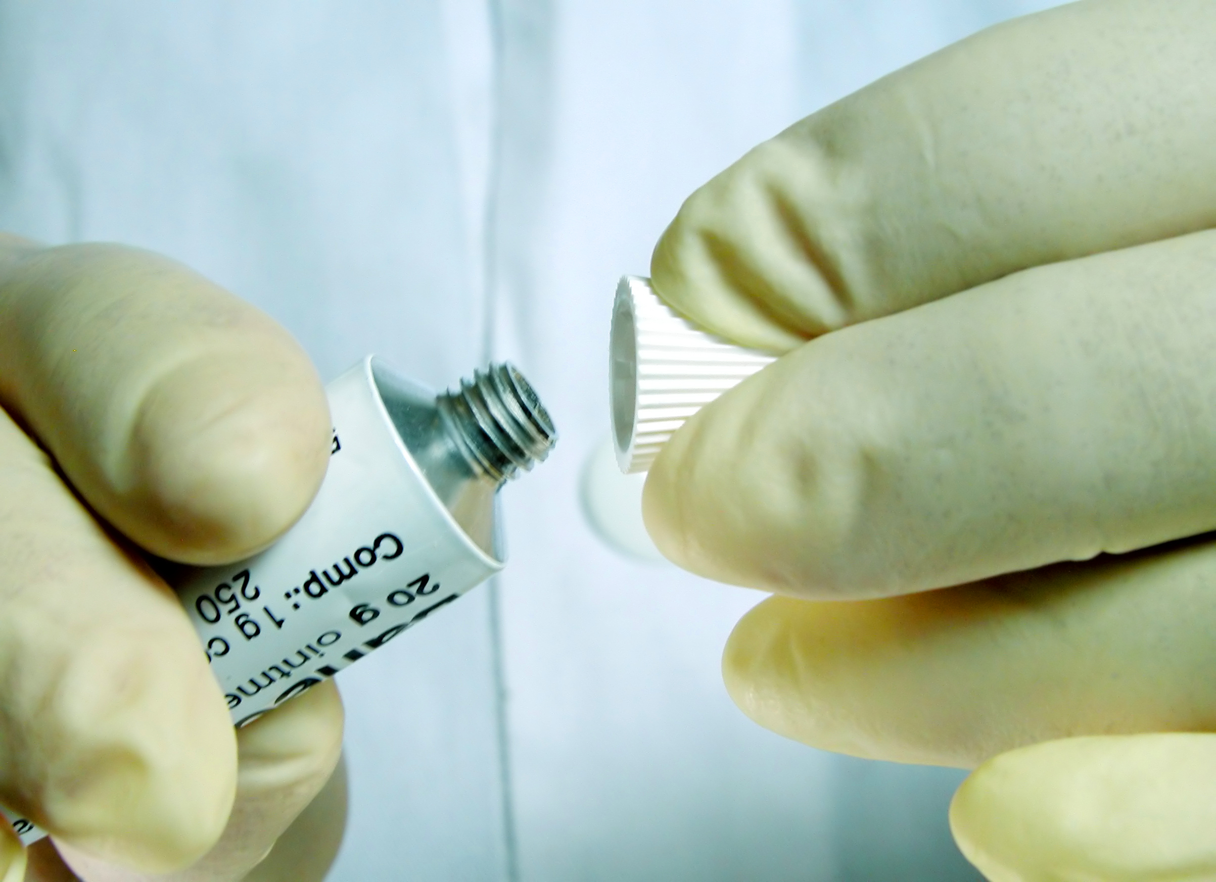 Doctors hand opening a cream tube