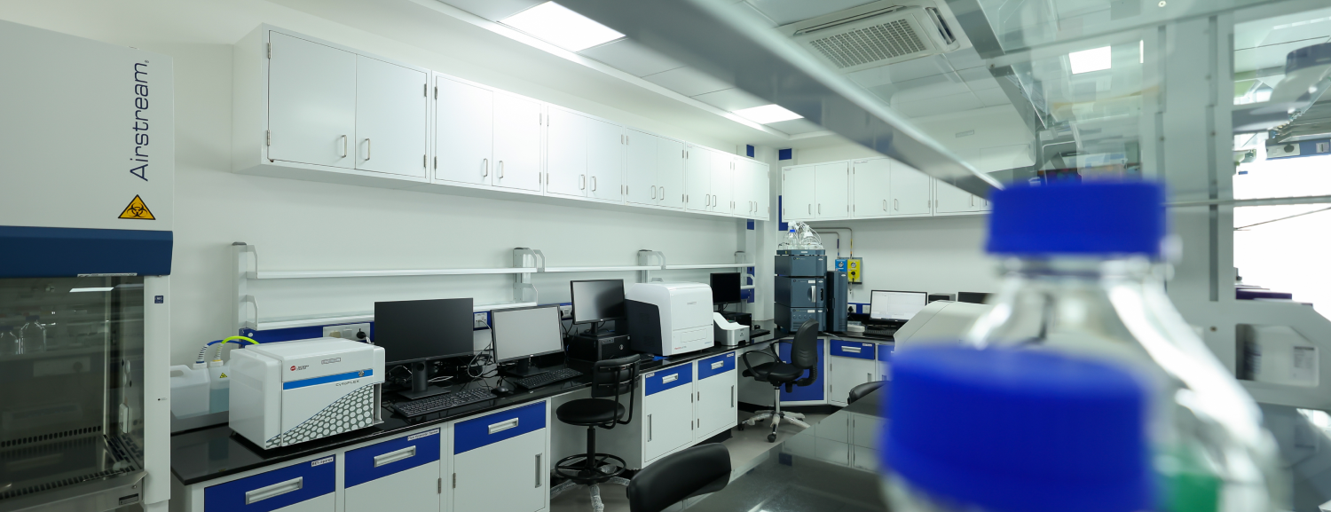 storage cabinets, and blue-capped laboratory bottles in the blurry foreground